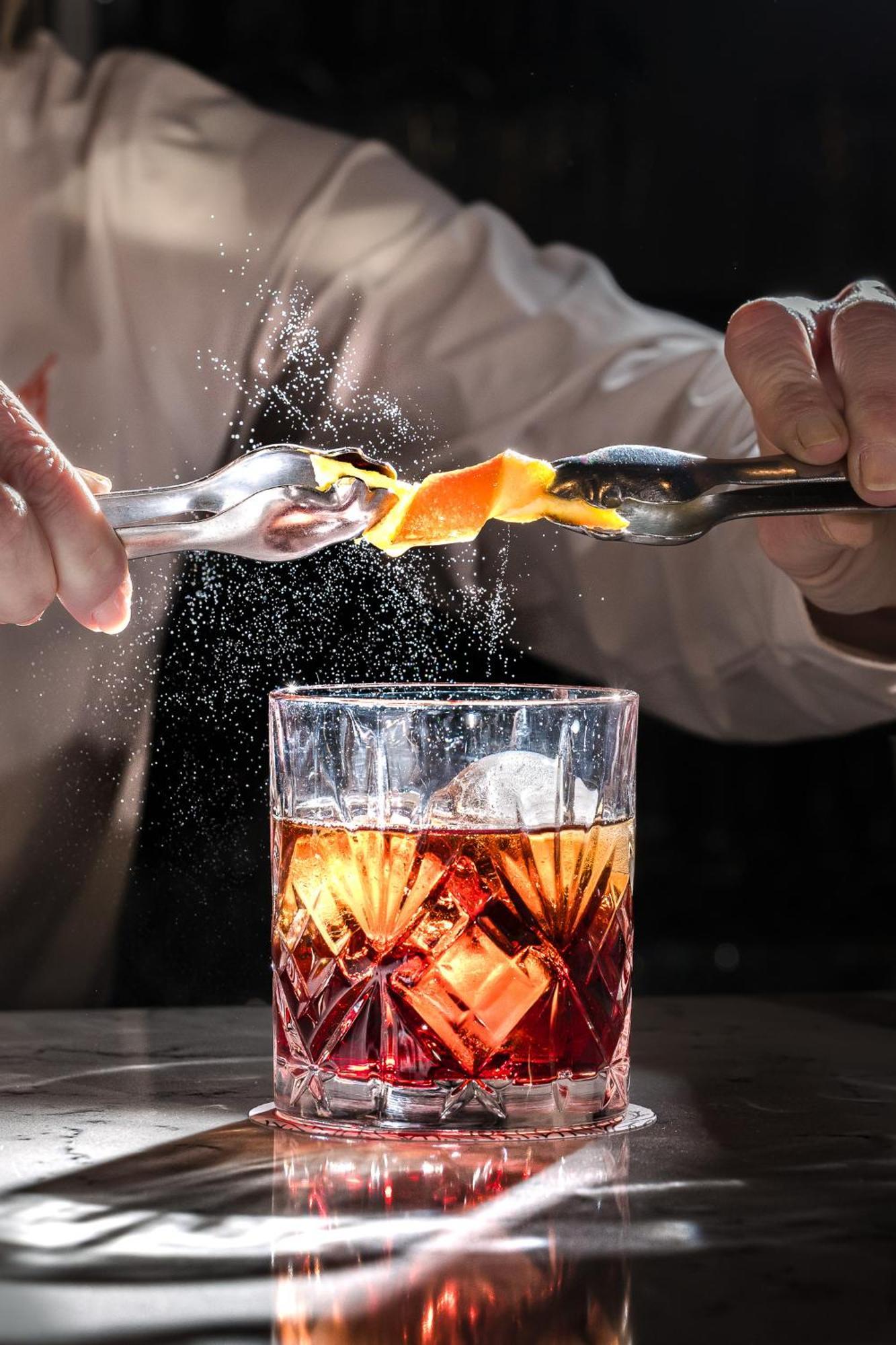 오스페스 팔라시오 데 아레날레스 앤 스파 Caces 외부 사진 A bartender adding a lemon twist to a cocktail
